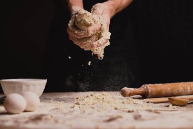 atış erkek el ahşap masa üstünde hamur yoğurma kırpılmış