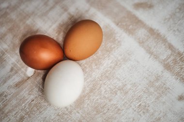 beyaz ve kahverengi pişmemiş tavuk yumurtası üstten görünüm masa üzerinde  