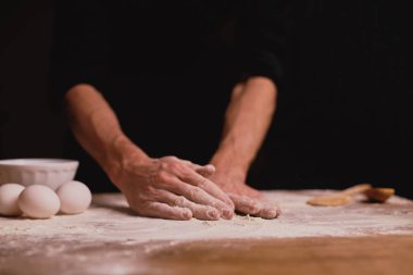 adam ahşap masa üzerinde hamur yoğurma kadeh kırpılmış