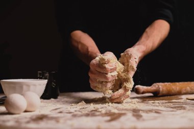 atış erkek el ahşap masa üstünde hamur yoğurma kırpılmış