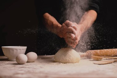 ahşap masa üzerinde hamur yoğurma adam orta bölümünde