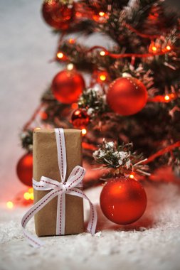 hediye kutusu kırmızı parlak topları ve ışıklı garland ile Noel ağacı altında 