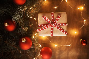 ahşap arka plan üzerinde hediye kutusu ve kırmızı topları ile Noel ağacı