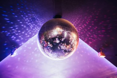 shiny disco ball hanging in night club, night party background clipart