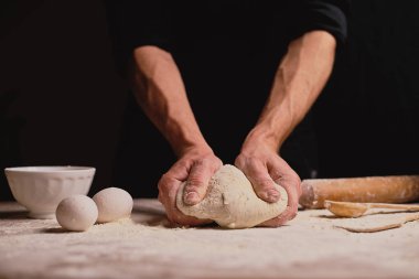 ahşap masa üzerinde hamur yoğurma adam orta bölümünde 