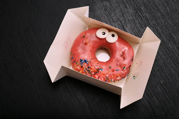 elevated view of donut with eyes in box on table