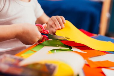 küçük çocuk kesme renkli karton kağıt makas masada ile kısmi görünümü