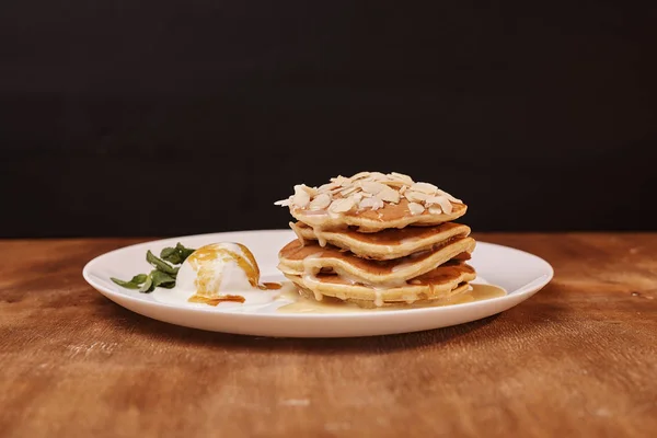 tasty pancakes with almond flakes ice cream on plate