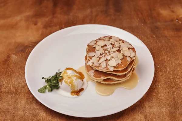 tasty pancakes with almond flakes ice cream on plate