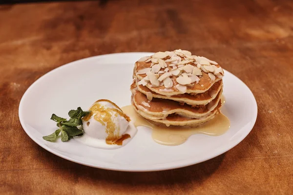 tasty pancakes with almond flakes ice cream on plate