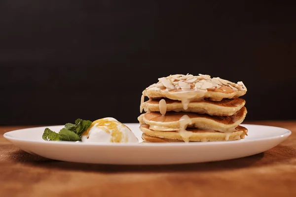 tasty pancakes with almond flakes ice cream on plate