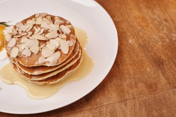 tasty pancakes with almond flakes ice cream on plate