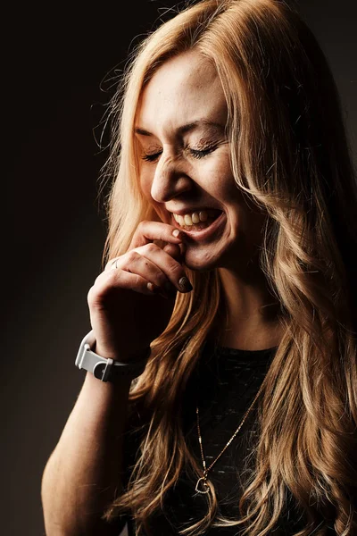 Laughing young woman on dark background