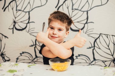 Küçük çocuk gösteren thumbs yukarı süre oturan içinde masa ile gıda