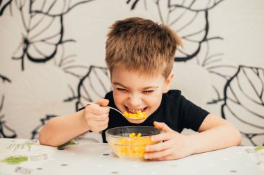 Masada kase gelen mısır yeme sevimli çocuk gülüyor 