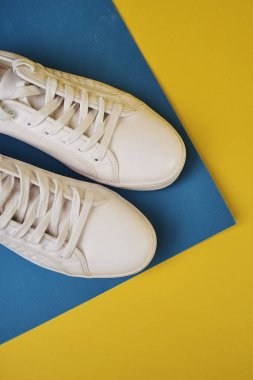 Renkli arka planda beyaz spor ayakkabıları stüdyo çekimi