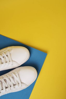 Renkli arka planda beyaz spor ayakkabıları stüdyo çekimi