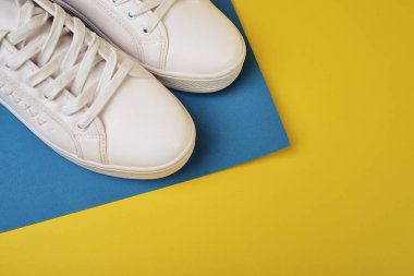 Renkli arka planda beyaz spor ayakkabıları stüdyo çekimi