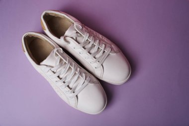 Mor arka planda beyaz spor ayakkabıları stüdyo çekimi