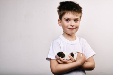 Küçük çocuk gri arka plan üzerinde köpek yavrusu tutan