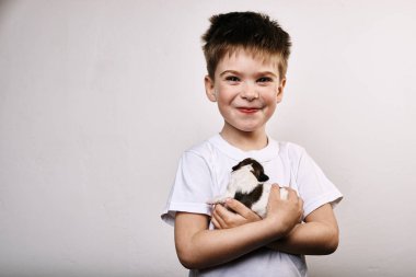 Küçük çocuk gri arka plan üzerinde köpek yavrusu tutan