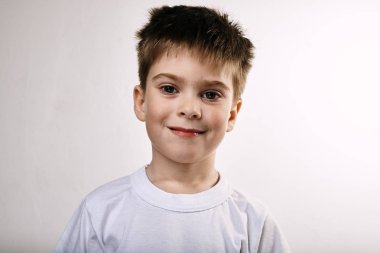 Gri arka planda poz veren mutlu sevimli çocuk