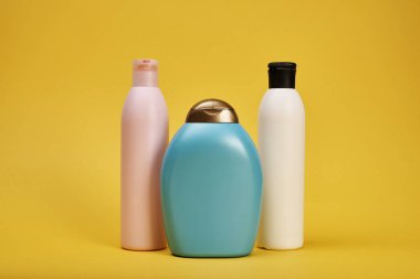 Sarı arka plan üzerinde saç şampuanı ve jel duş ile şişe Stüdyo çekim