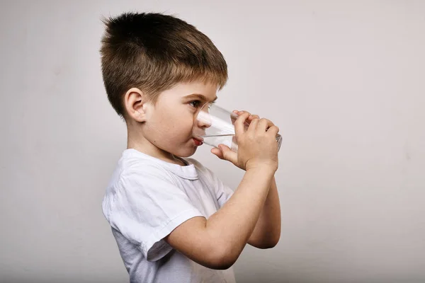 Студійний Знімок Маленького Хлопчика Чашкою Води Сірому Фоні — стокове фото