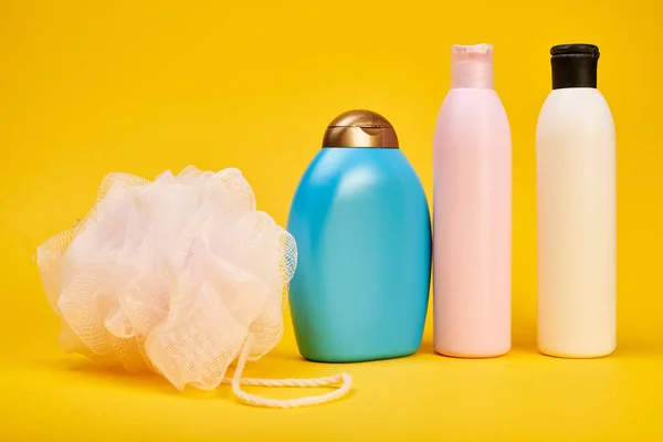 Studio shot of hair shampoo, sponge and gel showers on yellow background