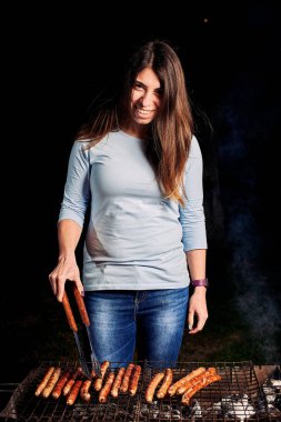 Gülümseyen genç kadın ızgara sosis 