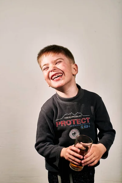 Adorable Niño Pequeño Con Taza Jugo Sobre Fondo Gris — Foto de Stock