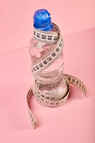 Measuring tape and bottle of water, diet concept