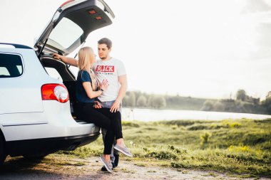 gezi sırasında birlikte araba bagajı yakınında duran güzel genç çift