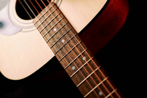 close-up shot of acoustic guitar on black