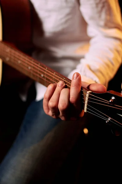 黒でアコースティックギターを弾く男のクロップドショット — ストック写真