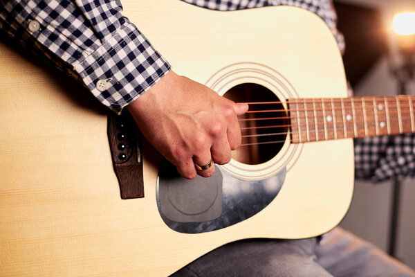 cropped shot of man playing acoustic guitar on black