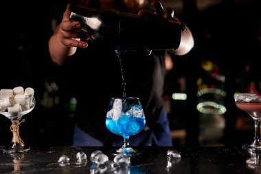 barda mavi kokteyl yapan barmen kadın kırpılmış atış