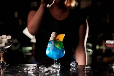barda mavi kokteyl yapan barmen kadın kırpılmış atış