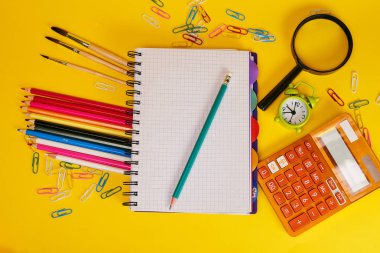 Eğitim kavramı. Sarı arka planda okul için kırtasiye 