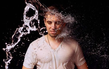 Karanlık arka planda genç adam su Sıçramaları