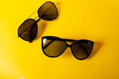 Sarı arkaplanda güneş gözlüğü