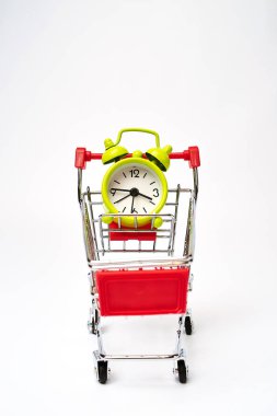 beyaz arka plan üzerinde çalar saat ile alışveriş arabası