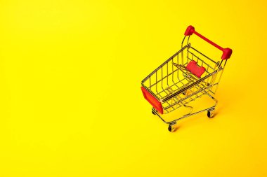 sarı arka plan üzerinde alışveriş arabası
