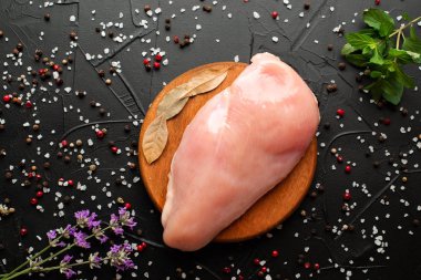 Koyu arka plan üzerinde çiğ tavuk göğüs filetosu