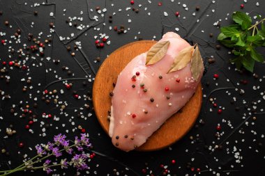 Koyu arka plan üzerinde çiğ tavuk göğüs filetosu