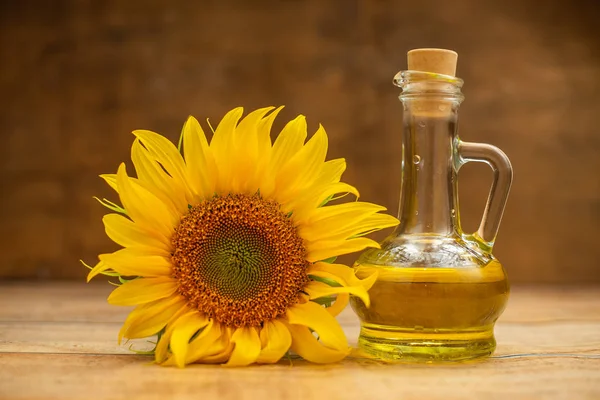sunflower oil and sunflower plant on wooden background