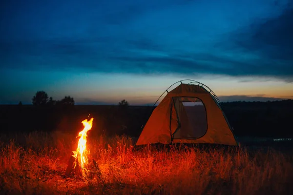 Tourist tent in camp among meadow in the mountains at sunrise