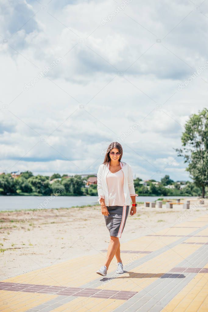 Slim young woman on beach in sunglasses