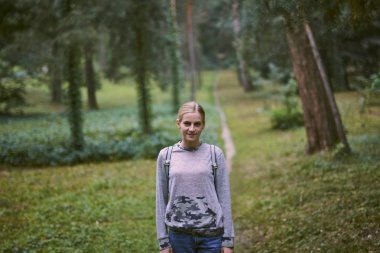 Parkta sırt çantası ile genç kadın 