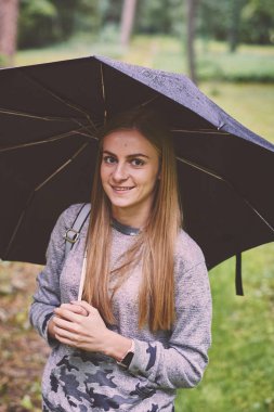 Ormanda şemsiyeli genç kadın